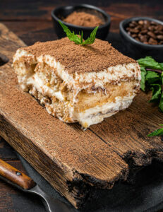 italian-dessert-tiramisu-cake-with-cocoa-and-mint-on-a-wooden-board-dark.jpg