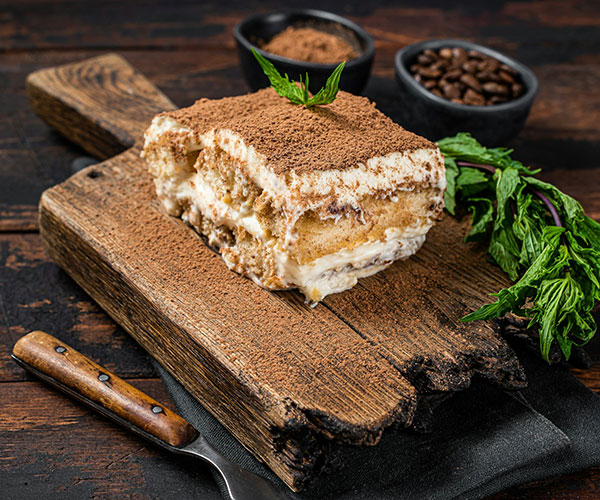 italian-dessert-tiramisu-cake-with-cocoa-and-mint-on-a-wooden-board-dark1.jpg